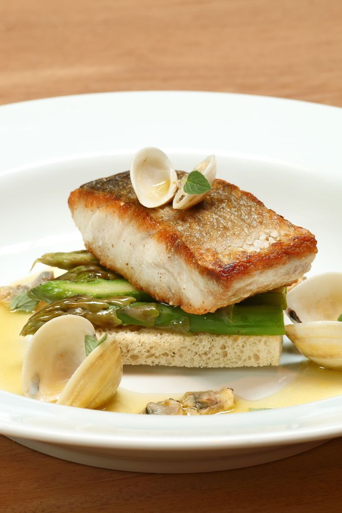 services-02 A delectable fish filet served with asparagus and clams, elegantly plated.