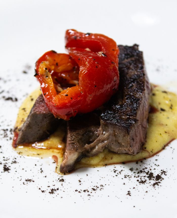 Succulent Wagyu beef steak served with grilled red peppers and a creamy sauce. Perfect for fine dining.